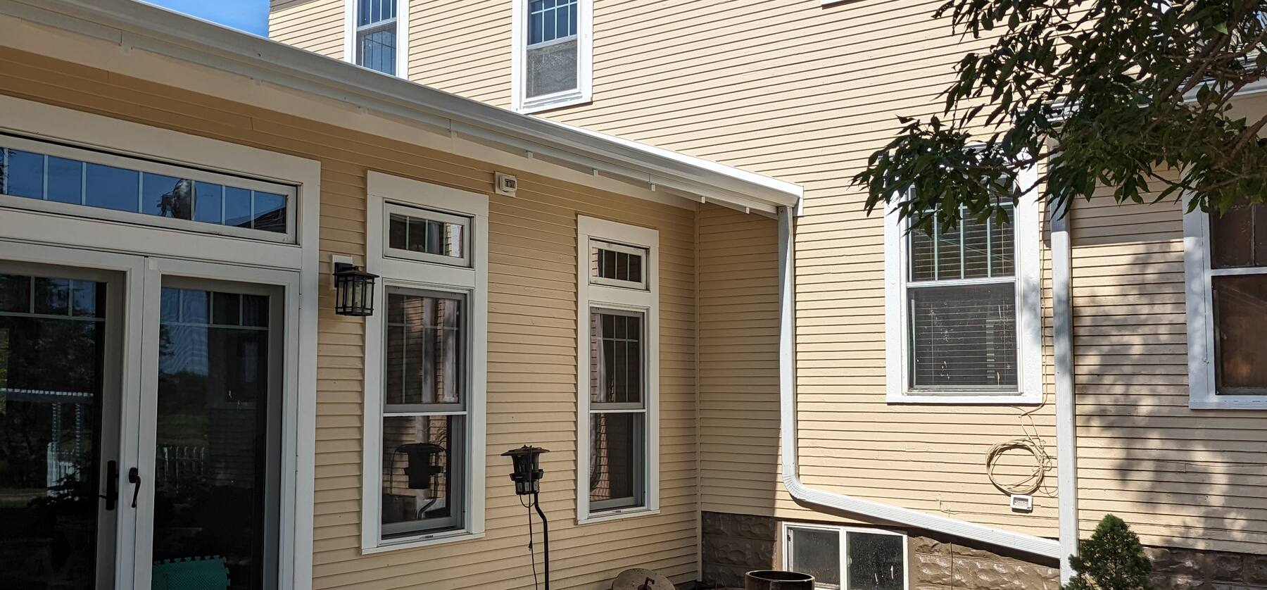 older two story home and its addition painted a warm cream