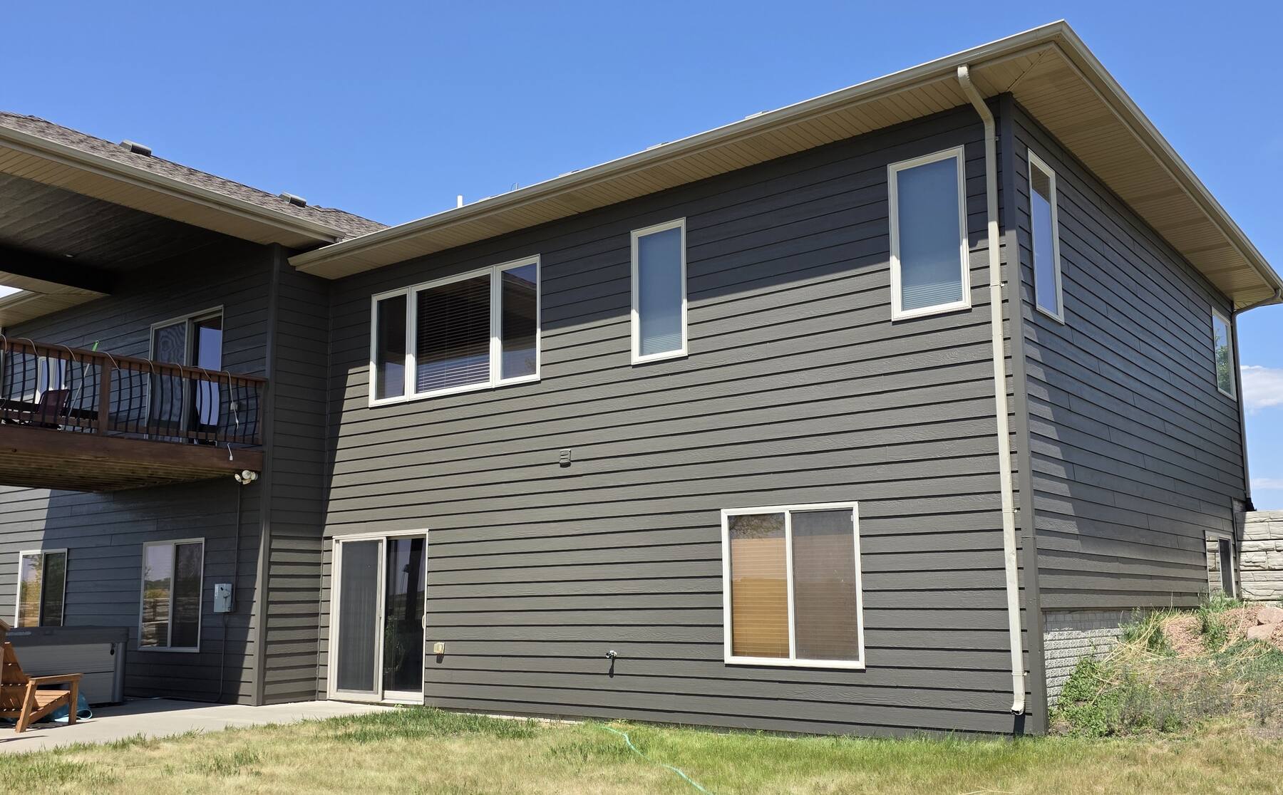 two story house repainted charcoal gray under a clear sky