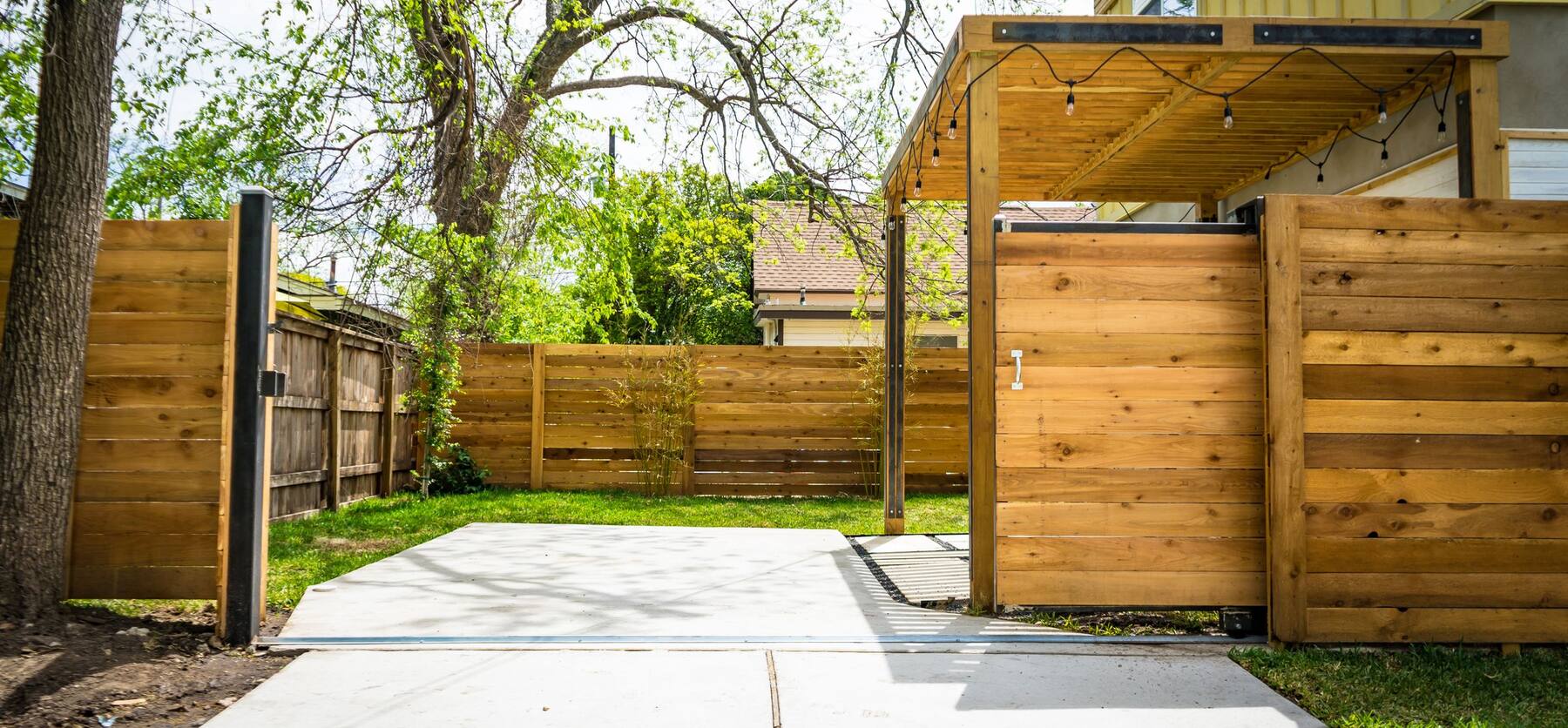new horizontal cedar privacy fence in a sunlit backyard
