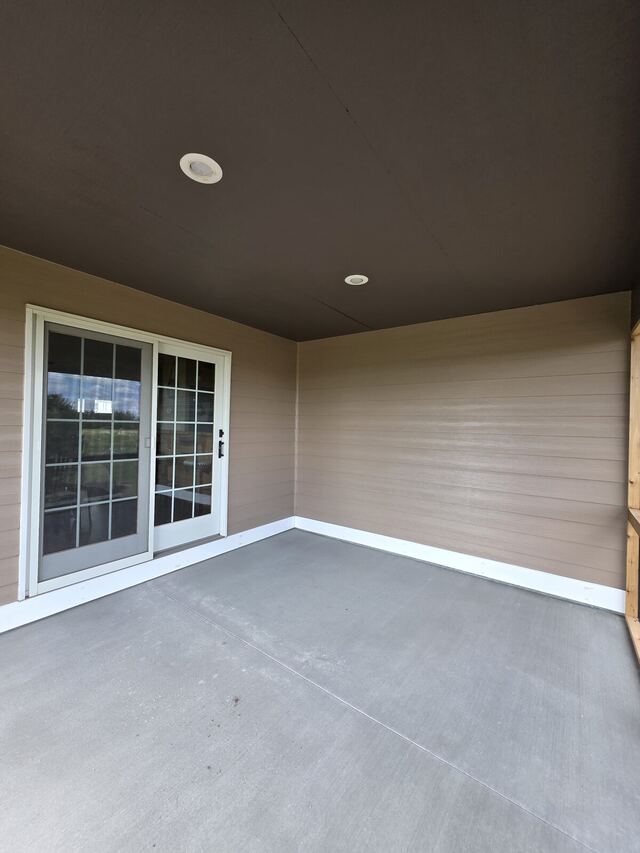 After: covered patio with a bare wood ceiling painted dark bronze and the siding freshly painted