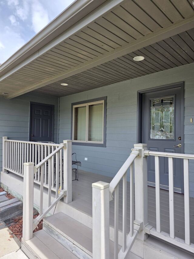 After: covered front porch with siding, entry door and trim repainted in blue gray