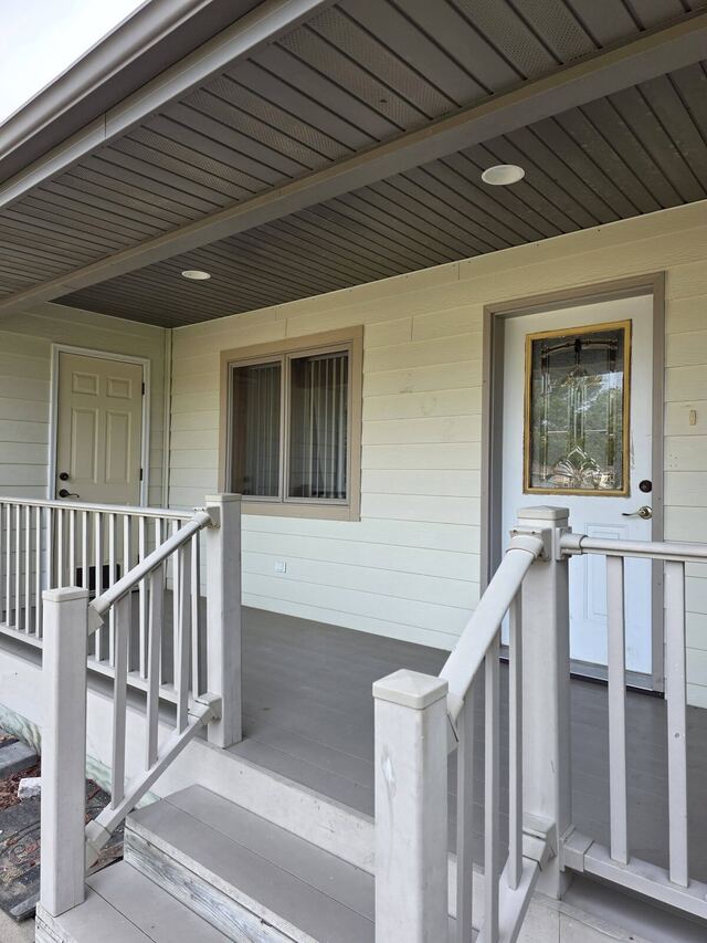 Before: covered front porch with siding, entry door and trim repainted in blue gray