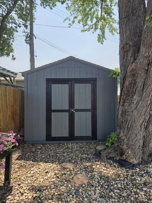 After: backyard garden shed repainted from green to gray with black trim on the doors