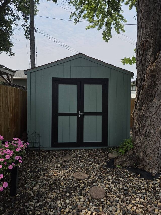 Before: backyard garden shed repainted from green to gray with black trim on the doors