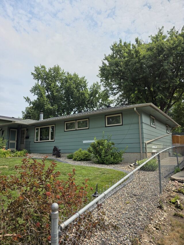 Before: mid-century ranch house repainted from pale green to dark slate with black and cream window trim