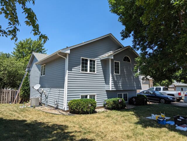 After: split level house repainted from green to blue gray with white trim