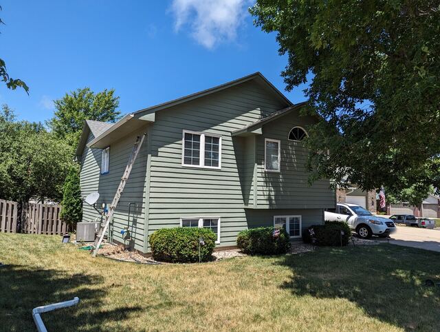 Before: split level house repainted from green to blue gray with white trim