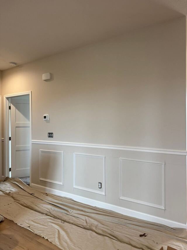 Before: hallway wall painted deep navy above white panelled wainscoting